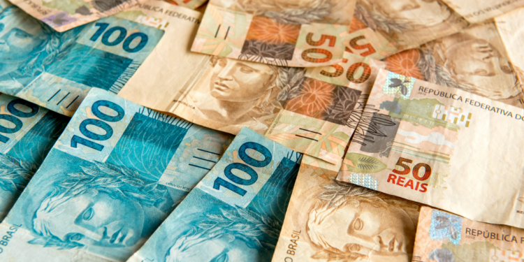 Notas de 50 e 100 reais espalhadas.