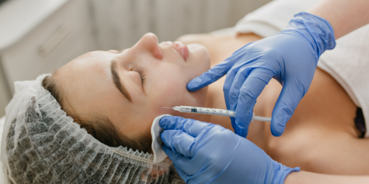 Aplicação de botox facial em clínica estética por profissional com luvas azuis.