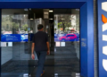 Cliente acessa agência da Caixa Econômica Federal em área urbana.