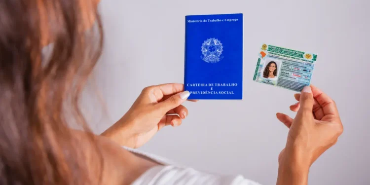 Mulher segurando carteira de trabalho e CNH.