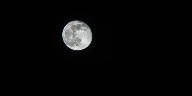 Céu escuro com lua em destaque.
