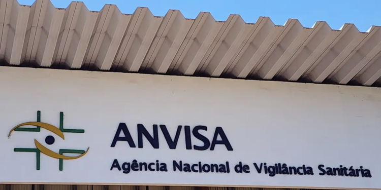 Fachada da ANVISA com logotipo verde e amarelo e letreiro da Agência Nacional de Vigilância Sanitária.