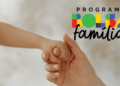 Mãe e criança de mãos dadas ao lado do logo do Bolsa Família.