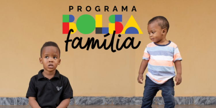 Dois meninos pequenos, um sentado e outro em pé, com logo do Bolsa Família ao fundo.