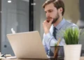 Homem olhando atento para notebook.