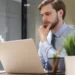 Homem olhando atento para notebook.
