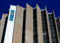 Prédio da Caixa Econômica Federal em destaque sob céu azul.