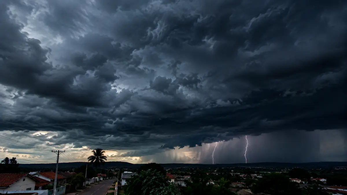 Tempestade se aproxima com nuvens escuras e raios ao fundo.