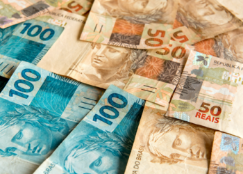 Notas de 50 e 100 reais representando dinheiro brasileiro em destaque.