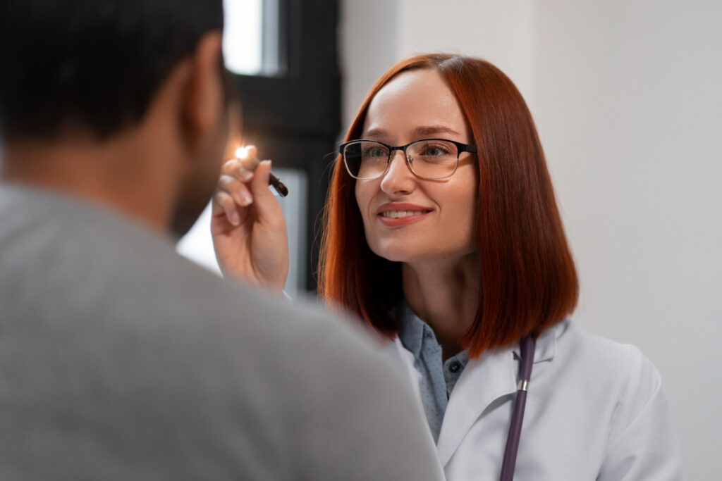 Imagem ilustrativa: médica examina os olhos de paciente com lanterna, cena ligada à cirurgia de catarata e glaucoma pelo SUS