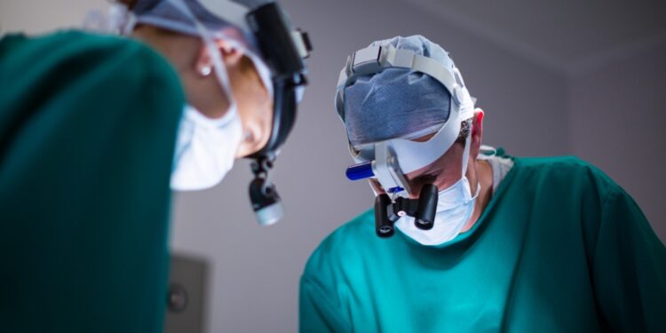 Imagem ilustrativa: cirurgiões com lupas em centro cirúrgico, em referência à cirurgia de catarata e glaucoma pelo SUS