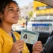 Nova motorista segura carteira de habilitação dentro do carro, representando o aumento nos pedidos de CNH após o programa CNH do Brasil.