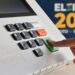 Imagem ilustrativa: dedo aperta a tecla confirma da urna eletrônica em arte das Eleições 2026, sobre o voto facultativo