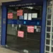 Entrada de agência da Caixa Econômica Federal com cartazes informando sobre greve dos bancários.