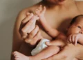 Imagem ilustrativa de mãe segurando recém-nascido no colo e tocando o pezinho do bebê, em referência à decisão do STF sobre a licença-maternidade