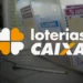 Balcão de uma casa lotérica com volantes da Lotofácil e de outras modalidades expostos, sobreposto pela marca Loterias Caixa.