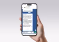 Imagem ilustrativa de mão segurando um celular com mensagem do perfil verificado GovBR no WhatsApp, que lista formas de fazer a Prova de Vida do INSS